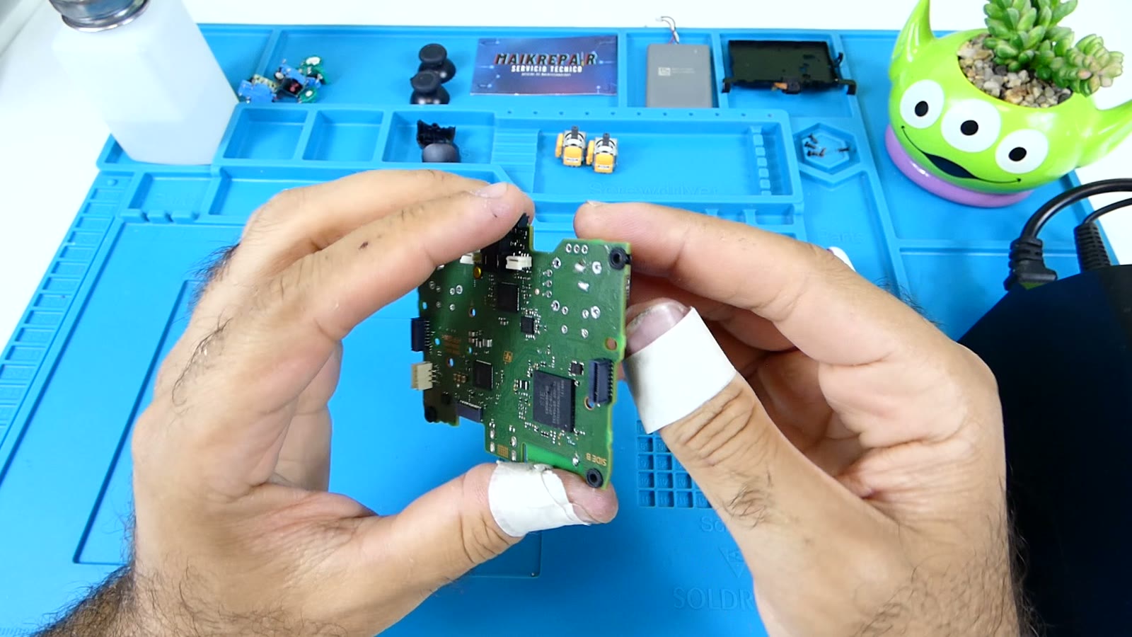 Placa pequeña de un mando sostenida en la mano mostrando el hueco y los pads donde iba soldado el módulo de joystick retirado